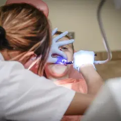 Dziecko u dentysty we Wrocławiu. Zabieg stomatologiczny z użyciem lampy polimeryzacyjnej. Najlepsze kliniki stomatologiczne we Wrocławiu.