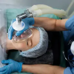 Pacjent pod maską tlenową, przygotowywany do zabiegu. To przykład, jak działa sedacja co to jest.
