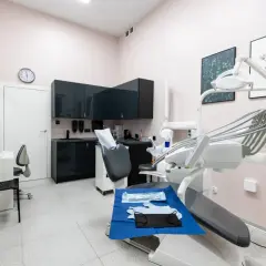 Nowoczesny gabinet stomatologiczny z fotelem dentystycznym i wyposażeniem.
