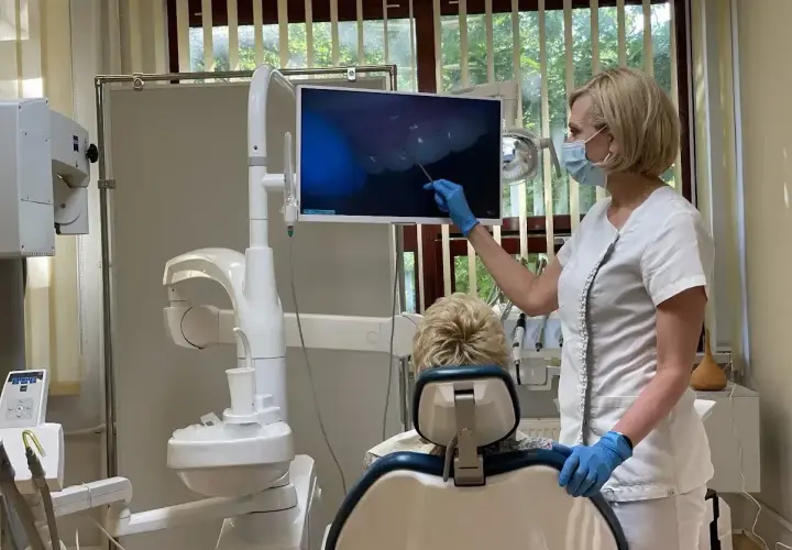 Dentystka pokazuje pacjentowi obraz z kamery wewnątrzustnej. Czy dentysta może wystawić L4? Tak, jeśli stan zdrowia pacjenta tego wymaga.