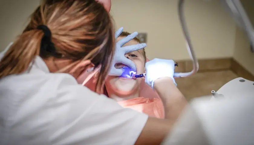 Dziecko u dentysty we Wrocławiu. Zabieg stomatologiczny z użyciem lampy polimeryzacyjnej. Najlepsze kliniki stomatologiczne we Wrocławiu.