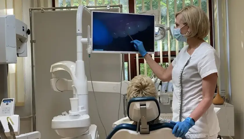 Dentystka pokazuje pacjentowi obraz z kamery wewnątrzustnej. Czy dentysta może wystawić L4? Tak, jeśli stan zdrowia pacjenta tego wymaga.
