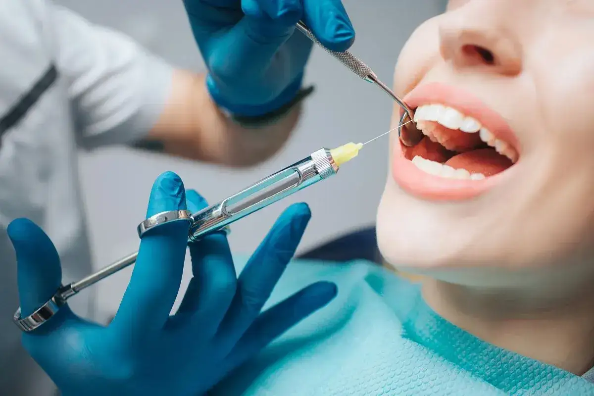 Dentysta podaje znieczulenie. Zastanawiasz się, ile kosztuje znieczulenie u dentysty? To ważna kwestia przed zabiegiem.