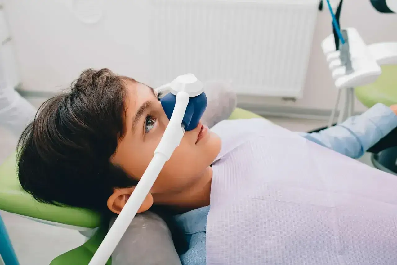 Chłopiec w masce gazowej u dentysty, aby zapobiec odruch wymiotny.