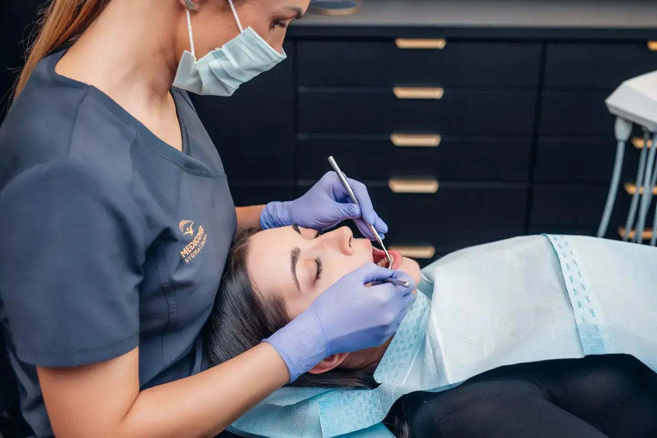 Dentystka bada zęby pacjentki. Szukasz informacji, jaki lek na ból zęba? Wizyta u stomatologa to najlepsze rozwiązanie.