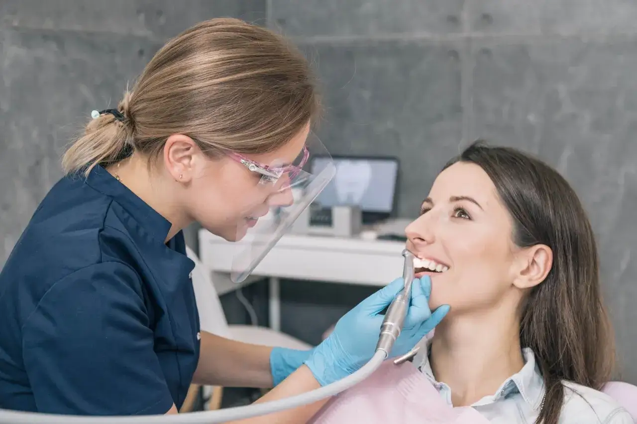 Dentystka leczy zepsuty ząb u pacjentki.